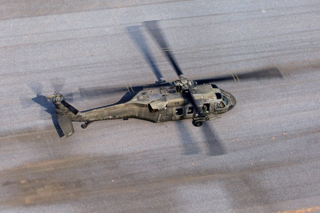 Top view of a military helicopter in motion on a runway.